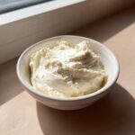 A small white bowl filled with creamy white sauce, likely the base for horseradish sauce for prime rib.