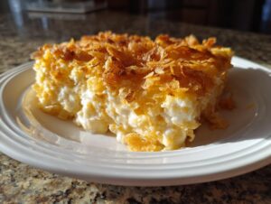 A close-up serving of creamy funeral potatoes recipe topped with golden brown, crispy corn flakes.