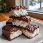 Stack of four chocolate-covered squares featuring a thick, fluffy white filling, characteristic of cool whip candy.