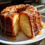 Close-up of a moist bacardi rum cake, sliced open, generously drizzled with a light rum glaze.