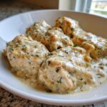 Close-up of tender chicken breasts smothered in creamy sauce for slow cooker garlic parmesan chicken.