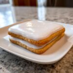 Close-up of a square sugar cookie sandwich topped with smooth, glossy white royal icing from the sugar cookie icing recipe.