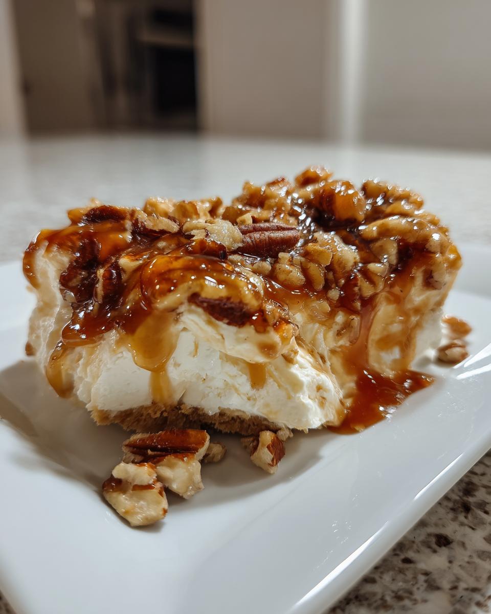 A close-up of a serving of creamy pecan pie dip topped with gooey caramel sauce and chopped pecans.
