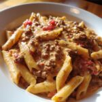 Close-up of creamy beef pasta made with penne noodles, rich sauce, and diced tomatoes, showcasing the amazing beef pasta.
