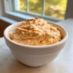 A close-up of creamy, orange-tinted homemade big mac sauce generously filled in a small white bowl.