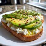 Close-up of avocado cottage cheese toast topped with olive oil and red pepper flakes.