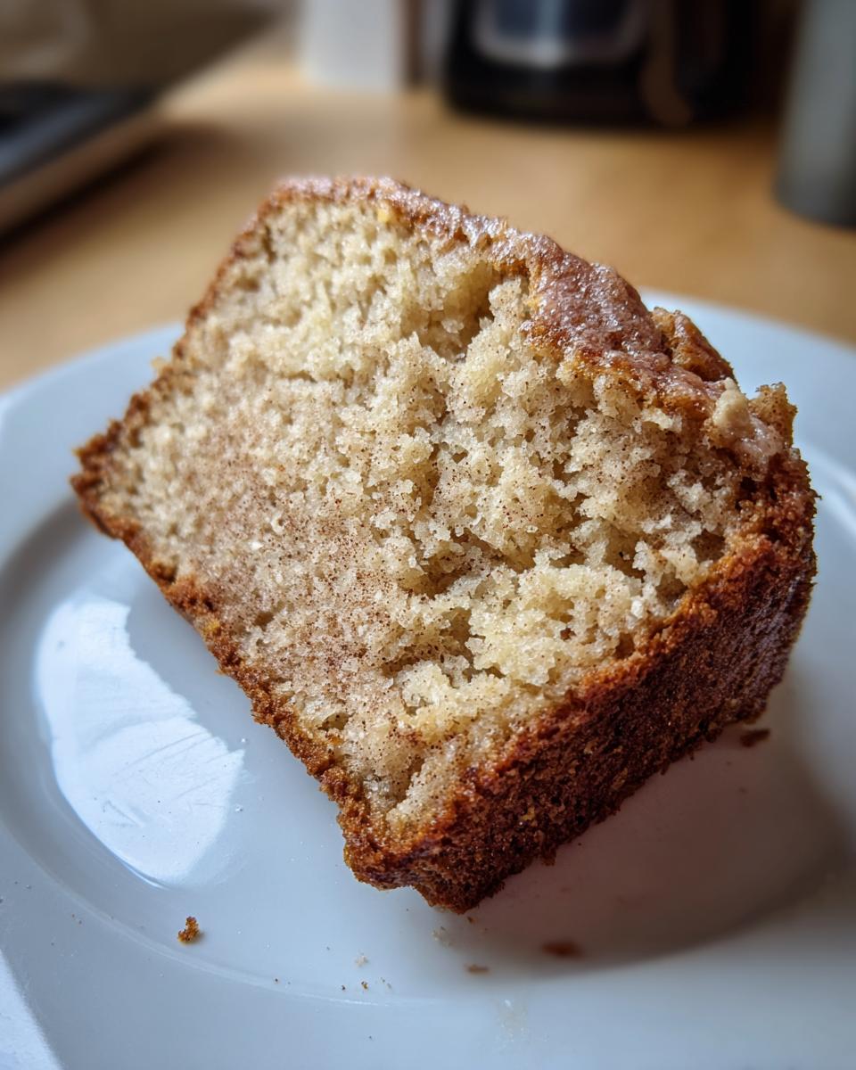 Close-up of a moist slice of cottage cheese banana bread with a sugary, browned crust.