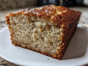 Close-up of a moist slice of cottage cheese banana bread showing a tender crumb and caramelized top.
