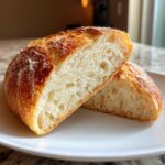 Close-up of crusty italian bread cut in half, showing the airy, open crumb structure.
