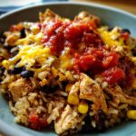 Close-up of a delicious 30-minute chicken burrito protein bowl with rice, chicken, black beans, corn, melted cheese, and salsa.