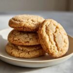 A stack of four soft, crinkly brown butter sugar cookies coated in cinnamon sugar, resting on a small plate.