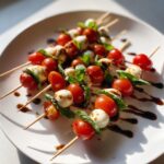 Close-up of fresh caprese skewers featuring cherry tomatoes, mozzarella balls, basil, and drizzled with balsamic glaze.