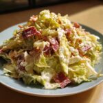 A heaping plate of creamy grinder salad featuring chopped lettuce, red meat pieces, and a thick dressing.