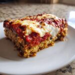 A hearty slice of 37-layer eggplant parmesan topped with melted mozzarella and rich tomato sauce.