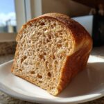 Close-up of a thick slice showing the soft, open crumb structure of homemade whole wheat bread.